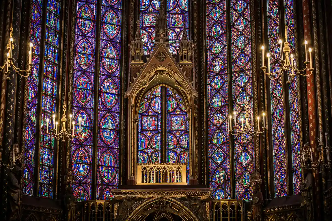 Stained-glass windows glowing around the relic tribune in the apse of Sainte-Chapelle's upper chapel, Paris